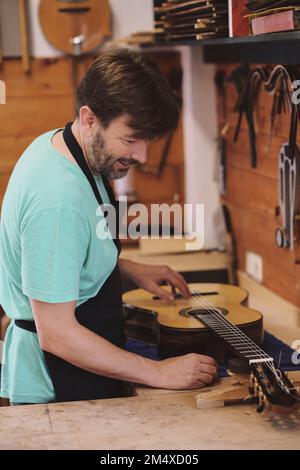 Liutaio che fa chitarra flamenco in laboratorio Foto Stock