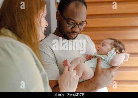 Uomo con donna che tocca i piedi della bambina Foto Stock