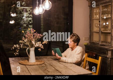 Donna anziana che usa lo smartphone a casa Foto Stock