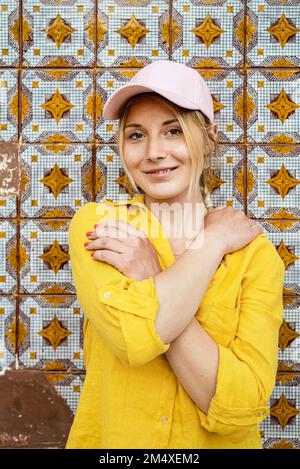 Giovane donna che indossa il cappuccio in piedi davanti alla parete modellata Foto Stock