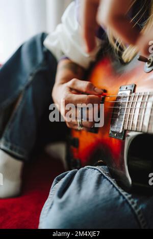 Mano del chitarrista che suona la chitarra elettrica in studio Foto Stock