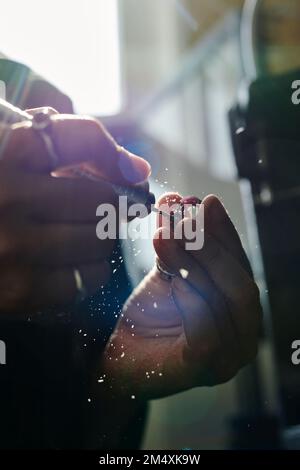 Mani di anello sagomatore artigiano con macinacaffè in officina Foto Stock
