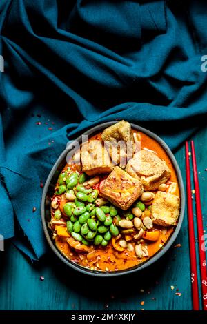 Ciotola di curry vegano pronto a mangiare con edamame e tofu Foto Stock