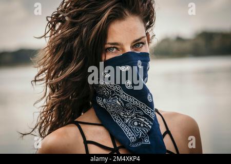Donna matura che copre il viso con fazzoletto Foto Stock