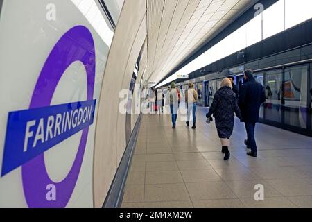 Farringdon TFL segno sul muro della stazione della metropolitana Elizabeth Line e ritorno di persone a piedi sulla piattaforma Londra Inghilterra UK KATHY DEWITT Foto Stock