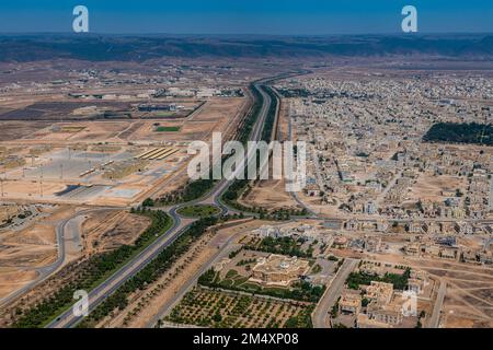 Oman, Governatorato di Dhofar, Salalah, veduta aerea di una lunga strada che si estende attraverso la città deserta Foto Stock