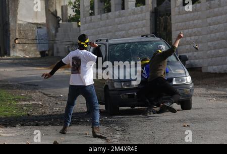 Nablus, Palestina. 23rd Dec, 2022. I manifestanti palestinesi usano le slingshots per colpire pietre contro i soldati israeliani durante gli scontri a seguito di una protesta contro l'espansione degli insediamenti ebrei nel villaggio di Kufr Qadoom, vicino a Nablus, il 23 dicembre 2022. Credit: Nidal Eshtayeh/Xinhua/Alamy Live News Foto Stock