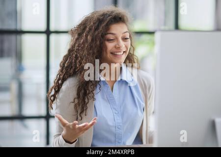giovane donna espressiva a bocca aperta che controlla gli sconti per lo shopping online seduto sul desktop . Foto Stock