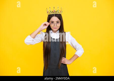 La ragazza egoista adolescente celebra la vittoria di successo. Bambino adolescente nella corona regina isolato su sfondo giallo. Principessa in tiara. PROM party. Grave Foto Stock