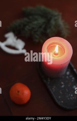 Cavallo del giocattolo di Natale, candela, tangerini e cono di pino. Articoli per le vacanze invernali per l'arredamento della casa. Giacitura piatta Foto Stock