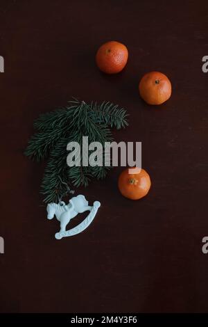 Cavallo del giocattolo di Natale, tangerini e pinone. Articoli per le vacanze invernali per l'arredamento della casa. Giacitura piatta Foto Stock