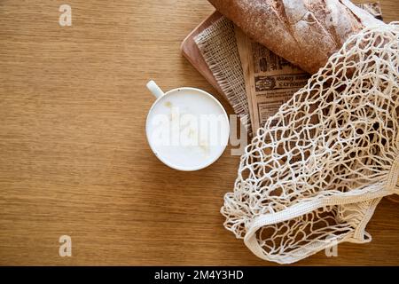 Baguette fresca con cappuccino su tavolo di legno. Colazione francese. Spazio di copia. Foto Stock