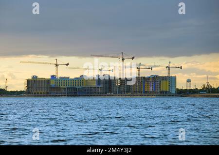 Gru di sollevamento a torre in alto edificio residenziale di costruzione di appartamenti. Sviluppo immobiliare in riva al mare Foto Stock