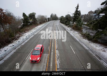 Seattle, Washington, Stati Uniti. 23rd dicembre 2022. Una macchina viaggia da sola lungo il West Seattle Bridge mentre una tempesta di ghiaccio avvolge la parte occidentale di Washington. Il ponte è la strada principale per il quartiere West Seattle di Seattle. Credit: Paul Christian Gordon/Alamy Live News Foto Stock