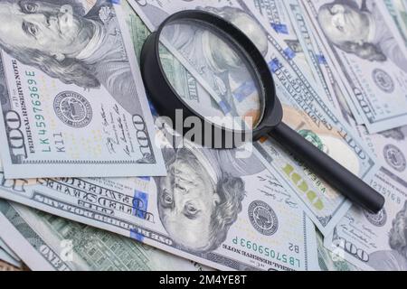 Lente d'ingrandimento è posta sopra di dollaro USA le banconote Foto Stock