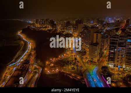 Vista aerea del quartiere di Miraflores e la barriera corallina di Costa Verde con l'Oceano Pacifico a Lima, la capitale del Perù, di notte. Foto Stock