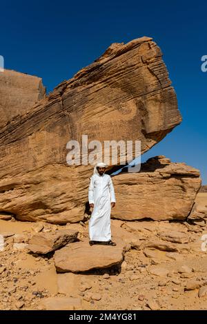 Uomo che indica le sculture di roccia, sito UNESCO Bir Hima Rock Petroglyphs e iscrizioni, Najran, Regno dell'Arabia Saudita Foto Stock