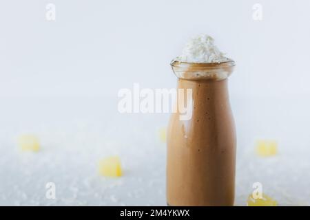 Un primo piano di un calice di milkshake al cioccolato su un tavolo, con la crema sulla parte superiore Foto Stock