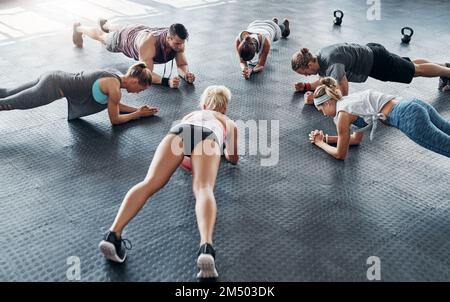 Erano tutti dedicati al fitness. una responsabilità che si sta allenando mentre si forma un cerchio in palestra. Foto Stock