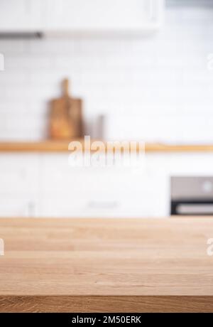 Banco in legno di quercia con spazio libero per il montaggio di un prodotto o layout sullo sfondo di una cucina bianca sfocata. Foto Stock