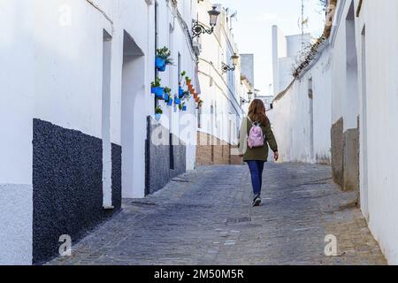 Turista femminile con la schiena a piedi attraverso le strette strade della pittoresca città di Medina Sidona, Cadice. Foto Stock