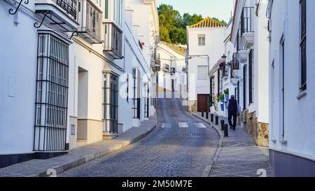 Uomo che cammina per le strette stradine del bianco e pittoresco villaggio di Medina Sidonia, Cadice. Foto Stock