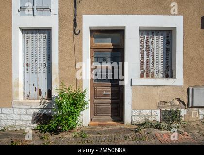 Vecchia casa facciata beige con persiane dipinte in grigio e porta d'ingresso in marrone nella città di la-Charité-sur-Loire, preso in un giorno di sole primavera, Burg Foto Stock