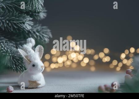 Un coniglio simbolo di 2023 tra le luci, ghirlande, alberi di Natale, calendario cinese anno simbolo con spazio copia Foto Stock