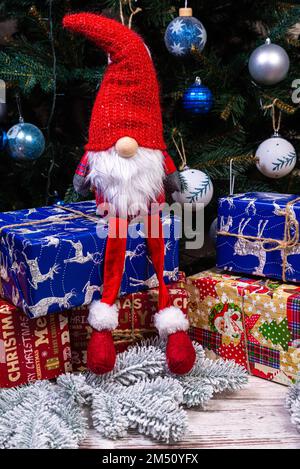 Decorazioni di Elfi di Natale. Quattro nani con regalo di Natale sono seduti su una mensola di legno. Concetto di Natale e Capodanno, biglietto d'auguri Foto Stock