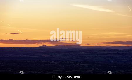 Tramonto sul Brecon Beacons visto da Cam Long Down, Dursley, Gloucestershire, Regno Unito Foto Stock