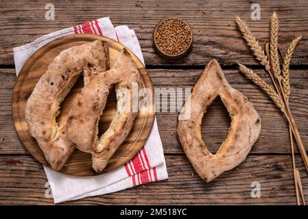 I tradizionali panini cotti in casa serbi (lepinja) e le spighe di grano maturo su tavola di legno. Foto Stock