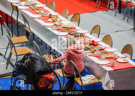 Sopot, Polonia. 24th Dec, 2022. Oltre 300 persone hanno partecipato alla cena della vigilia di Natale a Sopot, Polonia il 24 dicembre 2022 la cena della vigilia di Natale tradizionale polacca è stata organizzata dalla Caritas Poland organizzazione di beneficenza cristiana. La gente ha condiviso un wafer speciale quando si scambiano i saluti di Natale. I senzatetto e i poveri sono stati riaccompagnati da bigos, pierogi, pesce, pane e dolci tradizionali polacchi. Credit: Vadim Pacajev/Alamy Live News Foto Stock