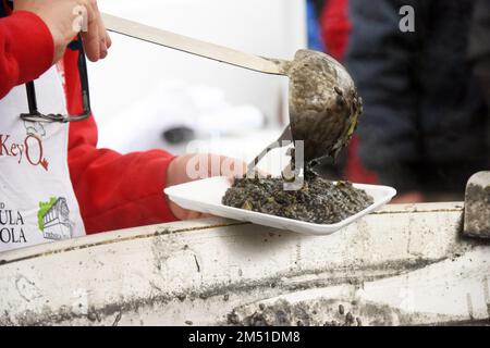 La preparazione del risotto nero in un grande padello di Pola si è svolta presso il mercato verde di Pola. Sotto il battone dello chef di Budimir Zizovic, il 24 dicembre 2022 a Pola, in Croazia, sono state preparate e distribuite circa 400 porzioni ai cittadini. Foto: SASA Miljevic/PIXSELL Credit: Pixsell/Alamy Live News Foto Stock