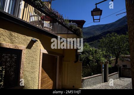 Stretta strada acciottolata che conduce ad un passaggio coperto in un vecchio villaggio Foto Stock