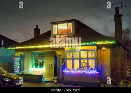 Luci di Natale sul bungalow suburbano degli anni '30 costruito da john Lawrence aspirazionale classe media sulla grande strada occidentale A82 Glasgow, Scozia, Regno Unito Foto Stock