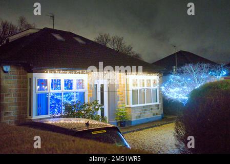 Luci di Natale sul bungalow suburbano degli anni '30 costruito da john Lawrence aspirazionale classe media sulla grande strada occidentale A82 Glasgow, Scozia, Regno Unito Foto Stock