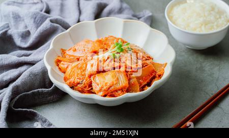 Kimchi ben fermentato fritto con cipolla verde tritata e aglio in una padella unta con olio, è un tipico contorno di solito mangiato con il riso. IO Foto Stock