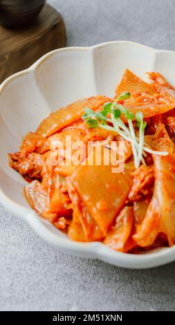 Kimchi ben fermentato fritto con cipolla verde tritata e aglio in una padella unta con olio, è un tipico contorno di solito mangiato con il riso. IO Foto Stock