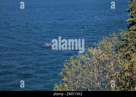 Gommone su un lago visto da lontano Foto Stock