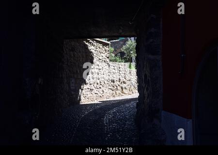 Vicolo coperto stretto tra vecchi edifici in un villaggio Foto Stock