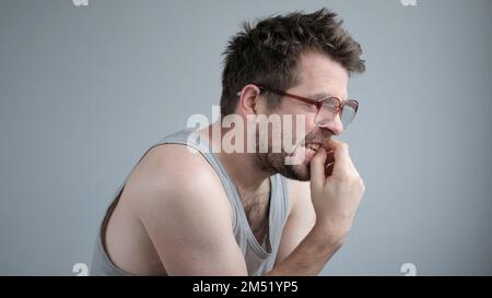 Uomo caucasico maturo che guarda stressato e nervoso con le mani sulla bocca mordente unghie. Foto Stock