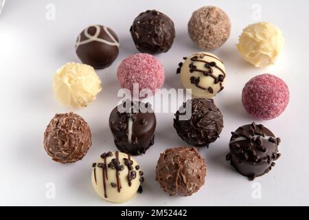 Una foto di molti cioccolatini diversi su sfondo bianco Foto Stock