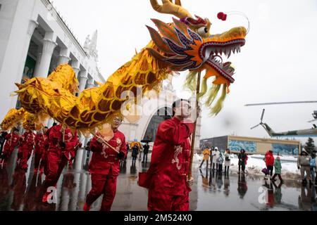 Mosca, Russia. 24th dicembre 2022. Le persone con colorati costumi di drago si riuniscono per celebrare il Solstizio d'Inverno Cinese (Festival di Donghzi) presso il centro espositivo VDNKh di Mosca, Russia. Si ritiene che la celebrazione, chiamata anche 'giorno del Ringraziamento Cinese', sia un simbolo della luce del giorno che si allunga e dà alle persone energia positiva. Nikolay Vinokurov/Alamy Live News Foto Stock