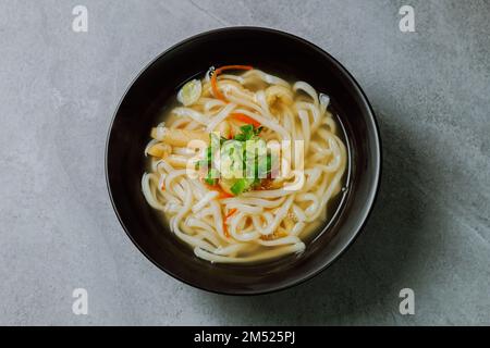 Kalguksu, zuppa di noodle in stile coreano: Tagliatelle fresche tagliate a coltello, preparate arrotolando la pasta di farina e affettando in tagliatelle sottili, cotte in salsa di acciuga. Zucch Foto Stock