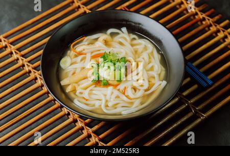 Kalguksu, zuppa di noodle in stile coreano: Tagliatelle fresche tagliate a coltello, preparate arrotolando la pasta di farina e affettando in tagliatelle sottili, cotte in salsa di acciuga. Zucch Foto Stock