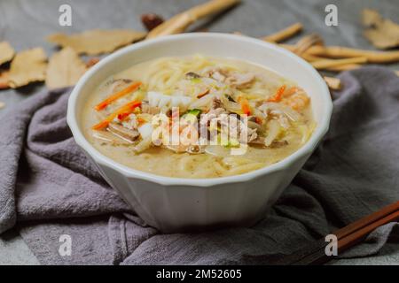 Zuppa di noodle bianche piccanti in stile coreano con pesce "hayan jjjampong" Foto Stock