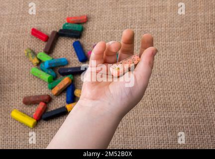 Usato pastelli di colore e una mano dei toddlers che tiene uno Foto Stock