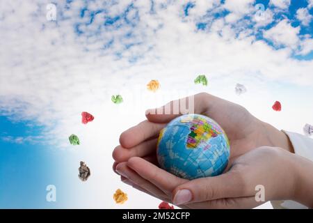Mano che tiene in mano un piccolo modello di globo Foto Stock