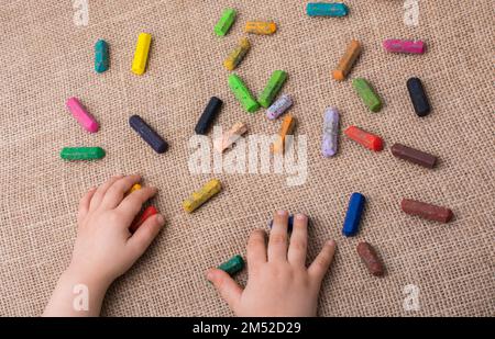 Usato pastelli di colore e una mano dei toddlers che tiene uno Foto Stock