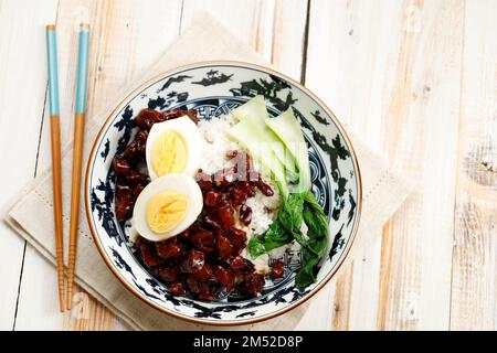 Lu Rou Fan, maiale brasato con cinque spezie cinesi e salsa di soia. Servito con Bok Choy e uova, vista dall'alto su un tavolo di legno Foto Stock
